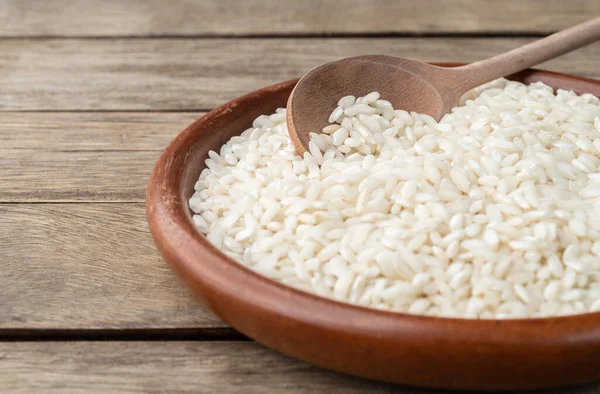 Dar odak, çiğ carnaroli risotto pilavı ahşap masa üzerinde fotokopi alanı ile birlikte..