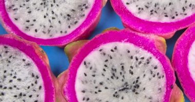 Pitayas or Dragonfruits halves over blue background.