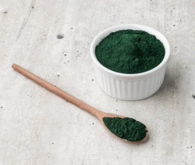 Kase ve kaşık içinde ahşap masanın üzerinde bir alg tozu..