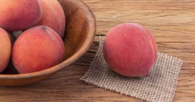 Şeftali, ahşap bir masanın üzerinde..