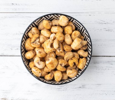 Canjica, hominy ya da beyaz mısır patlamış mısır, ahşap masanın üstündeki kasede tatlı patlamış mısır..