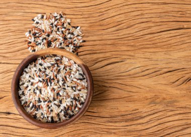 Tahta bir masanın üzerinde, fotokopi alanı olan bir kasede çiğ pirinç..