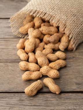 Tahta masanın üzerinde bir poşet içinde kabuklu fıstık yığını..