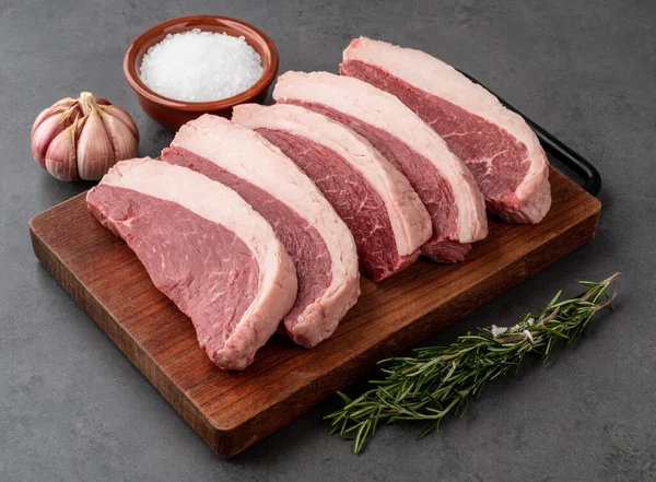 Çiğ Picanha dilimi ya da ahşap tahtanın üzerinde baharatlı et..