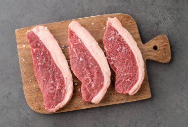 Çiğ Picanha dilimleri ya da ahşap tahtada tuz ile kıç eti..