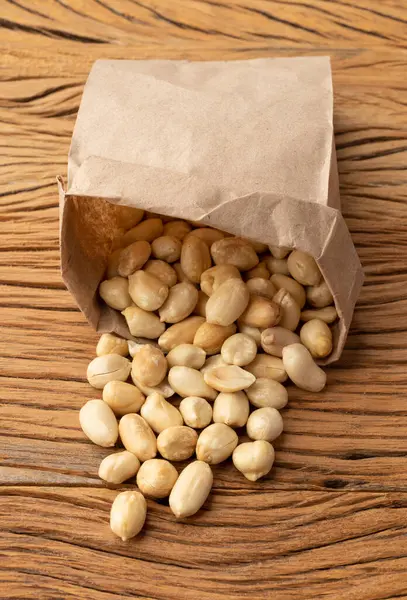 Amendoins Descascados Saco Papel Sobre Mesa Madeira — Fotografia de Stock