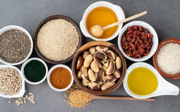 Verschiedene Superfoods Vor Grauem Hintergrund Chia Quinoa Hafer Leinsamen Honig — Stockfoto