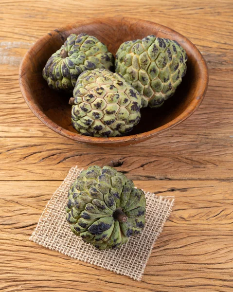 Sugar apples or custard apples in a bowl over wooden table.