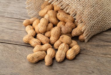 Tahta masanın üzerinde bir poşet içinde kabuklu fıstık yığını..