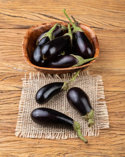 Tahta masanın üzerinde bir kasede küçük bebek patlıcanlar..