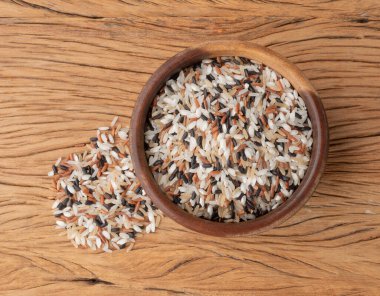 Tahta masanın üzerinde bir kasede çiğ pirinç..