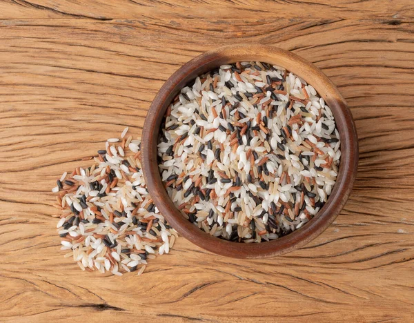 Tahta masanın üzerinde bir kasede çiğ pirinç..