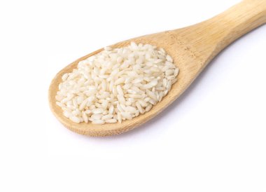 Raw carnaroli risotto rice on a spoon isolated over white background.