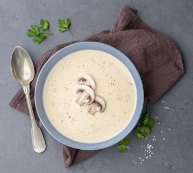 Bir kasede mantar çorbası. Arkaplanda baharatlar var..