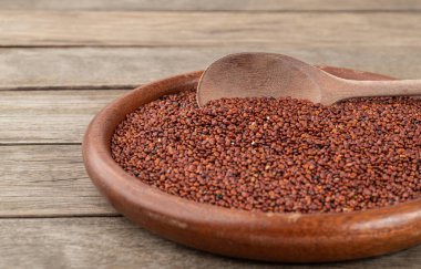 Dar bir odak noktası, ahşap bir tabakta çiğ kırmızı kinoa..