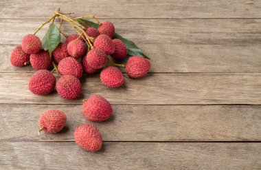 Ağaçların üzerinde yaprakları olan ve kopya alanı olan Lychees 'ler..