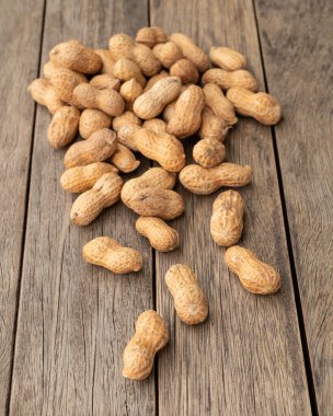 Ahşap masanın üzerinde kabuklu fıstık yığını.