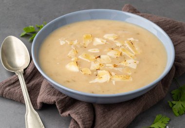 Bir kasede peynirli soğan çorbası ve arkaplanda baharatlar..