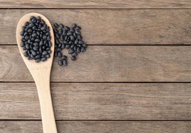 Tahta masanın üzerinde siyah fasulye ve fotokopi alanı..