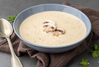 Bir kasede mantar çorbası. Arkaplanda baharatlar var..