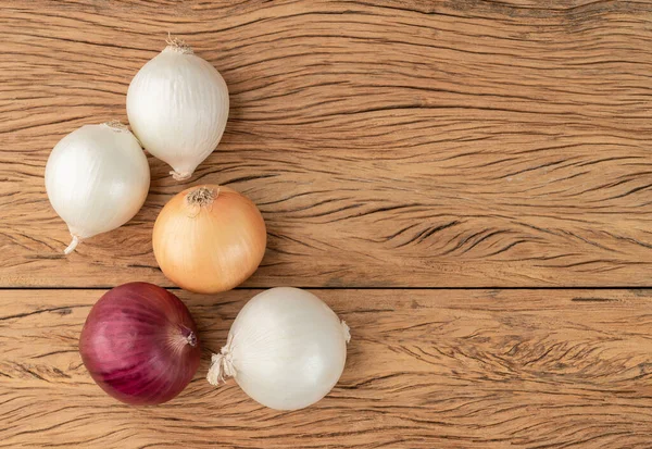 Verschiedene Zwiebeln Über Holztisch Mit Kopierraum — Stockfoto