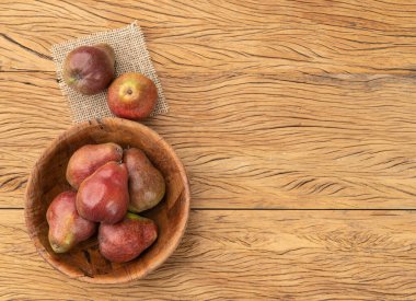 Fotokopi alanı olan ahşap bir masada kırmızı armutlar..