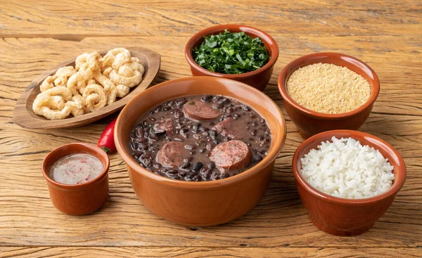 Pirinçli, lahanalı, farofalı ve çatırdayan tipik Brezilya feijoadası..