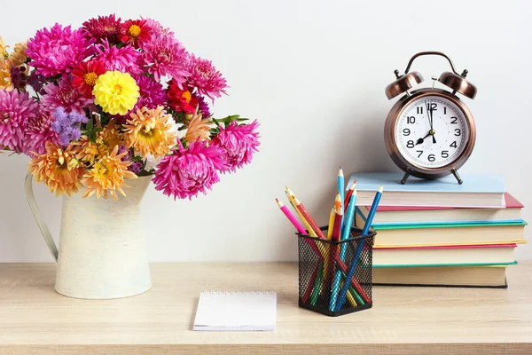 学生の職場に戻る秋の花束目覚まし時計と教科書 — ストック写真