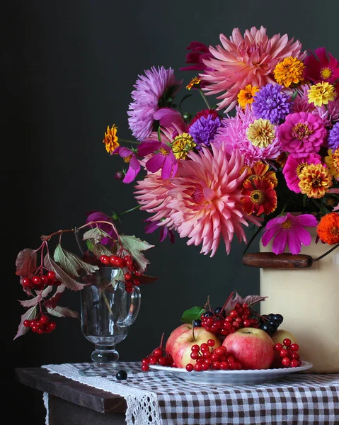 Натюрморт с цветами, ягодами и фруктами на темном фоне. — стоковое фото
