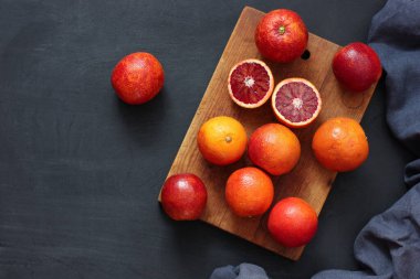 Siyah arka planda kanlı kırmızı portakallar..