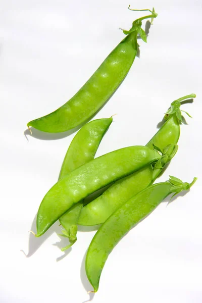 Peas, young green pods on a white — Stock Photo, Image