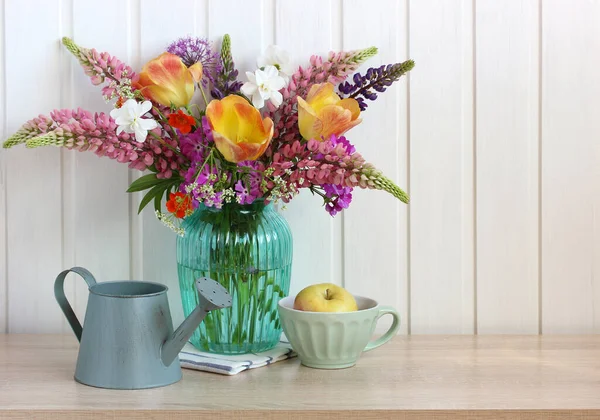 Frühling rustikale Komposition mit einem Strauß, einem Apfel und einer Gießkanne. — Stockfoto