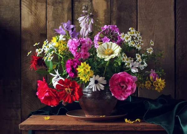 Rustic summer composition with a bouquet in a clay jug. — Stock Photo, Image