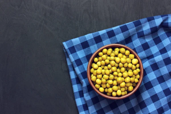 Canned peas in a bowl on a black background. — Stock Photo, Image