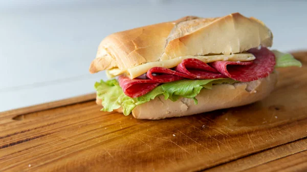 Vista Cercana Sándwich Casero Salami Queso Lechuga Sobre Plato Madera — Foto de Stock