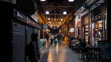İnsanlar San Telmo pazarındaki antikacılar arasında yürüyüş yapmaktan zevk alıyorlar.