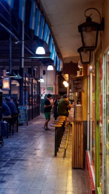 İnsanlar San Telmo pazarında yerel yiyeceklerin tadını çıkarıyorlar.