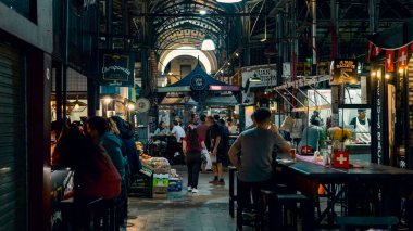 İnsanlar San Telmo pazarında yerel yiyeceklerin tadını çıkarıyorlar.