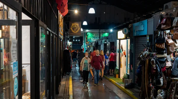 İnsanlar San Telmo pazarındaki antikacılar arasında yürüyüş yapmaktan zevk alıyorlar.