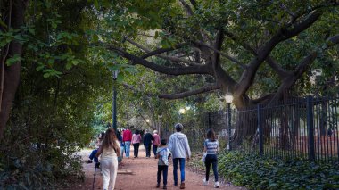  İnsanlar, Carlos Thays 'in Buenos Aires' teki botanik bahçesinde sıcak bir sonbahar öğleden sonrasında eğleniyorlar.