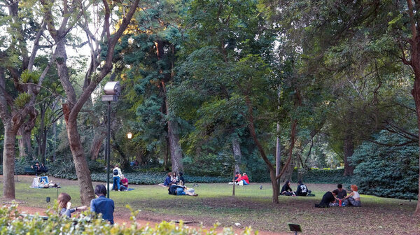 People enjoying a warm autumn afternoon in Carlos Thays botanical garden               