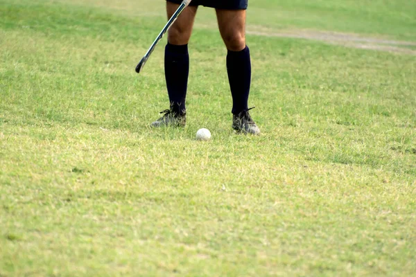 Hockey player standing beside ball to hit hockey ball