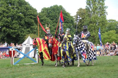 Hever, UK - 29 August, 2022: Re-enactment of a medieval jousting tournament. Knights on horseback ride towards each other carrying lances with the intention of delivering scoring blows or unseating their opponent.