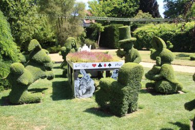 Harikalar Diyarı figüründeki Topçu Alice. Bu, uzun bir süre boyunca çalıları istenen şekle sokmayı içeriyor..