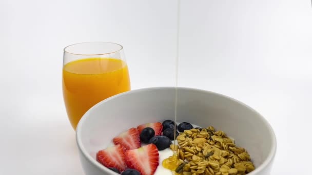 Pouring Honey Yogurt Granola Strawberries Blueberries Orange Juice Background — Stock Video