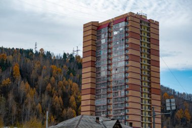 Sonbahar ormanlarında bir dağın arka planına karşı yüksek bir yerleşim yeri..