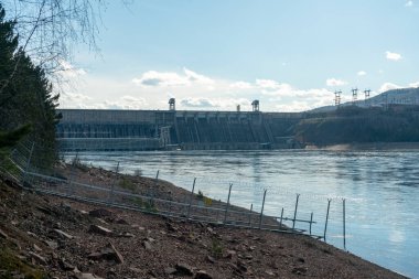 Rocky Nehri kıyısı hidroelektrik santralinin arka planında.