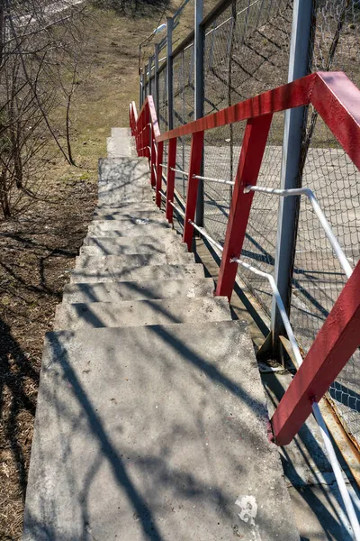 Узкая пешеходная лестница с красными перилами. — стоковое фото