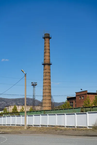 Beton çitin arkasındaki tuğla egzoz borusu..