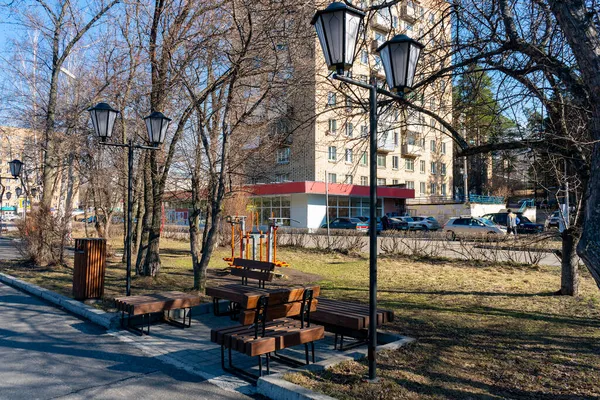 Träbänkar längs gränden med lyktor i parken. — Stockfoto